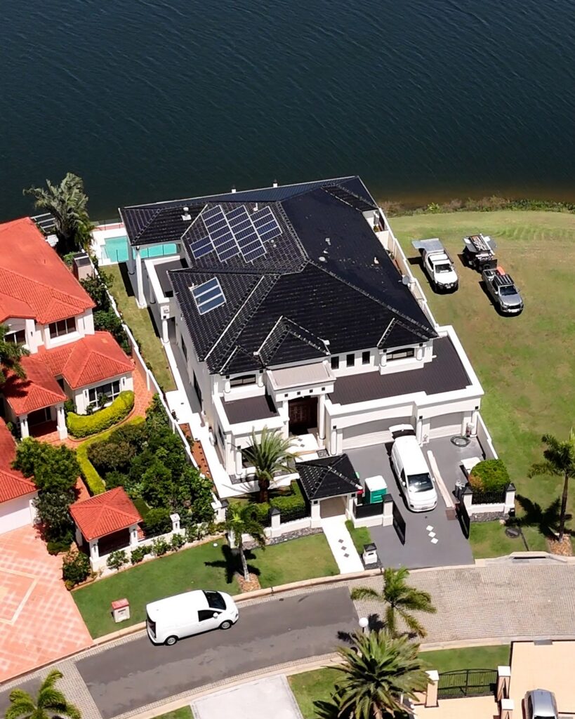 Aerial view of a freshly repainted white two storey waterfront home in Clear Island Waters, We Paint Gold Coast