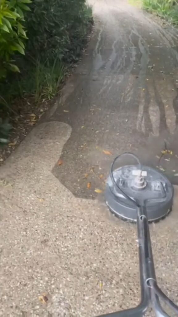 Surface cleaner pressure washing a concrete driveway, half cleaned, We Paint Gold Coast