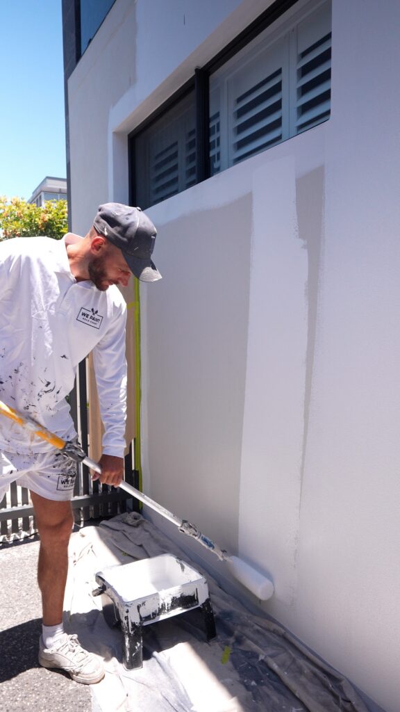 We Paint Gold Coast painter cutting in the exterior of a modern two storey home in Southport
