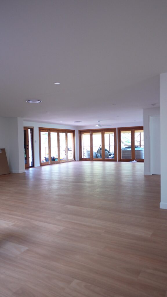 Freshly painted open plan living area with timber bifold doors in a Tallebudgera home, by We Paint Gold Coast