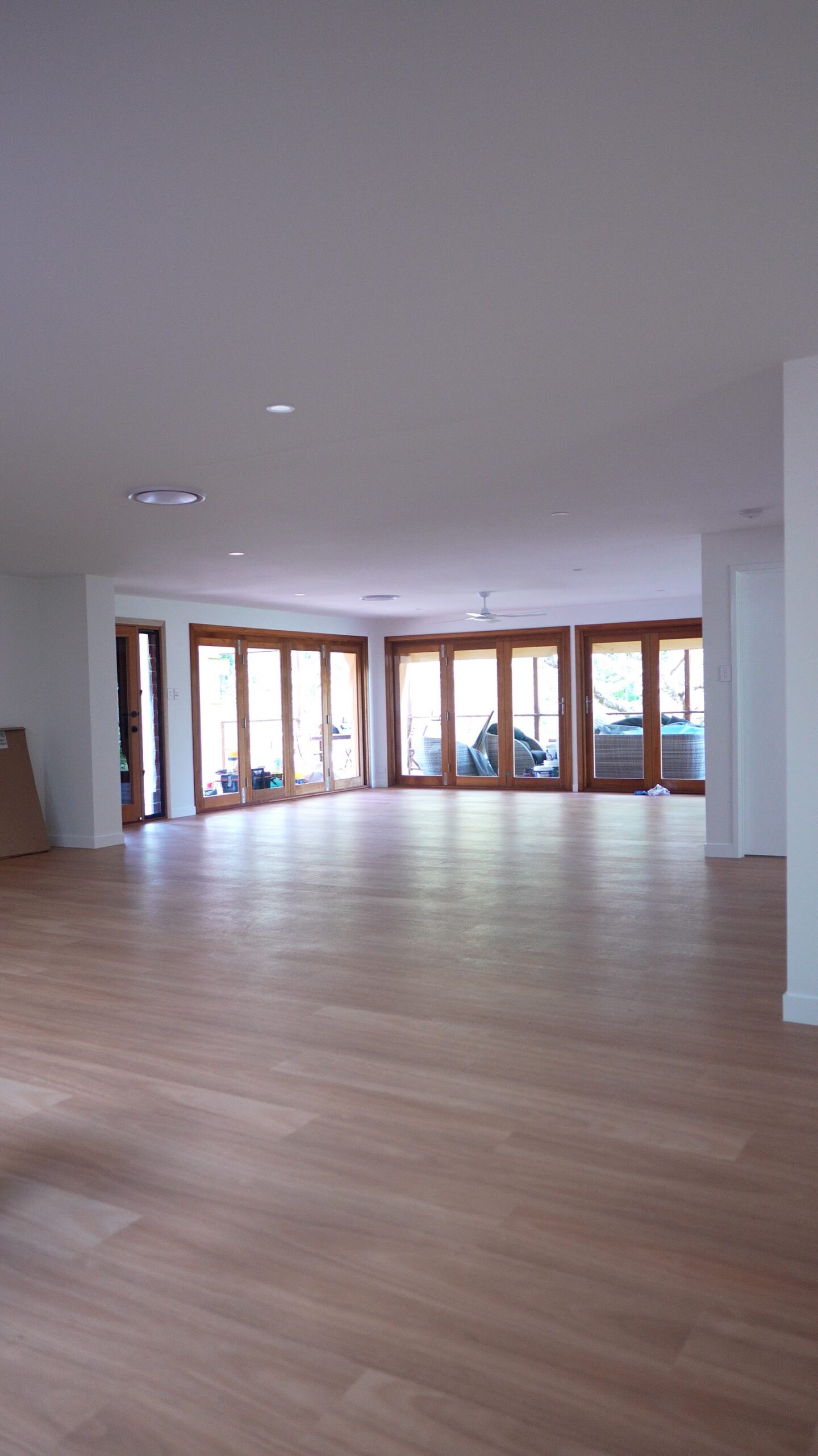 Freshly painted open plan living area with timber bifold doors in a Tallebudgera home, by We Paint Gold Coast